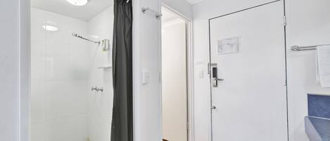 Un baño con ducha, inodoro y lavabo.