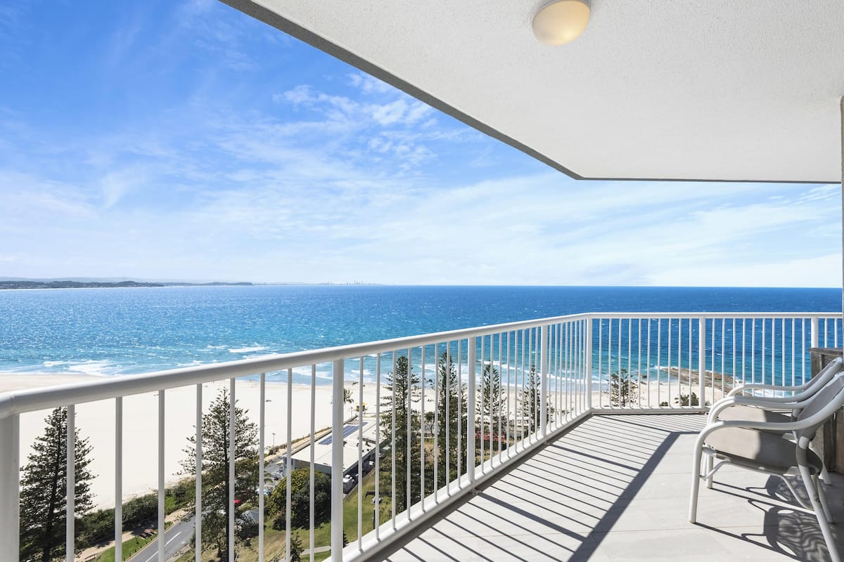 Een balkon met uitzicht op zee en strand.