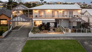 A modern motel with a large sign, a covered outdoor area, and a well-maintained lawn. - City Heart Motel (Warrnambool)