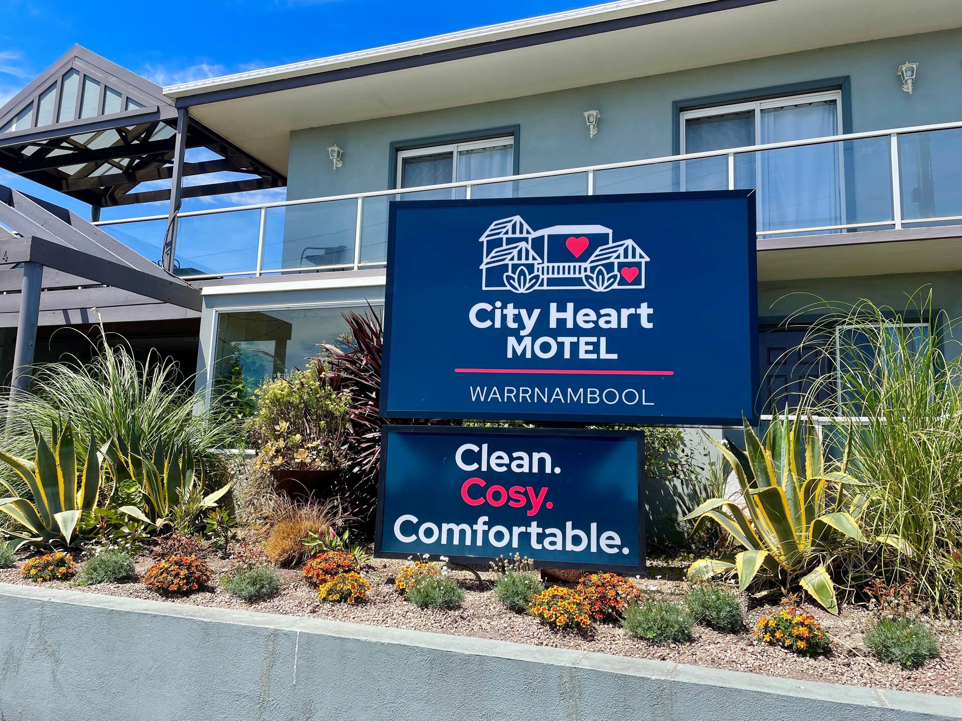 A sign for City Heart Motel in Warrnambool, highlighting features like cleanliness, coziness, and affordability.