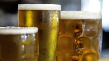 Drie bierglazen met schuim, vermoedelijk in een bar of café.