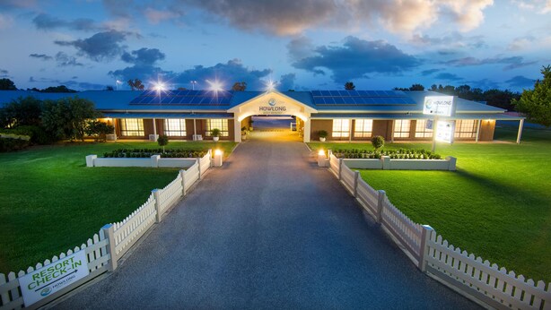 A resort entrance with a sign reading "HOWLONG RESORT" and solar panels on the roof.