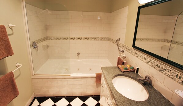 Un baño con bañera, lavamanos y espejo.