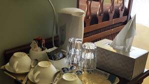 A breakfast table with white cups, saucers, and a box of tissues.