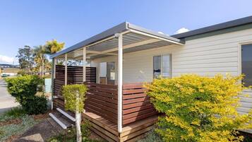 A modern house with a covered porch, a small garden, and a clear sky.