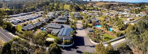 Vista aérea de um camping com trailers, casas móveis e uma piscina.