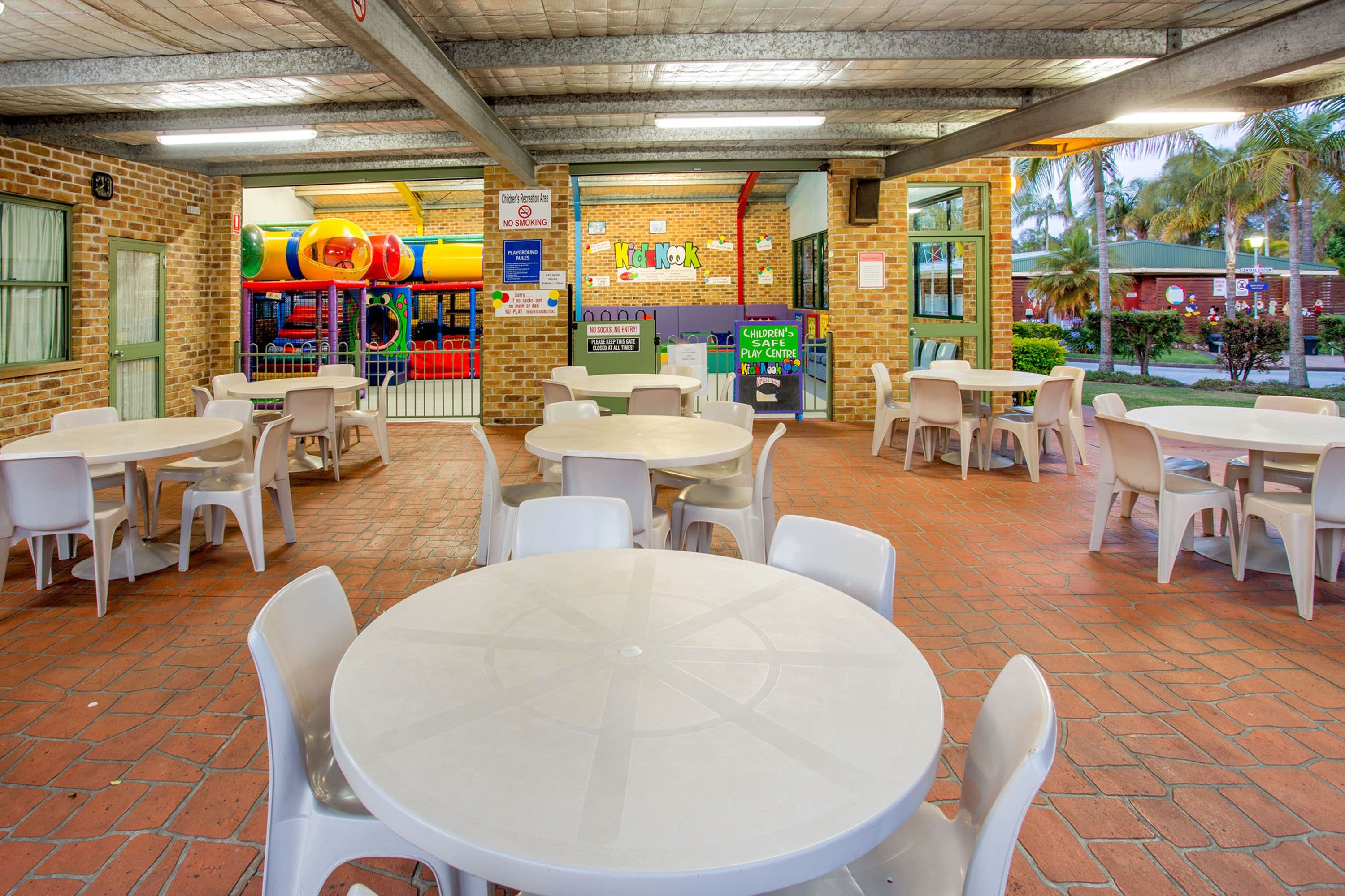 A children's play area with tables and chairs arranged for adults.