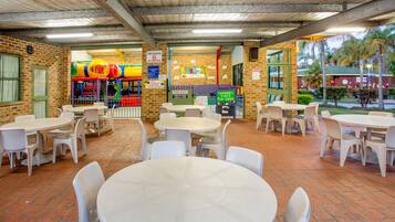 A children's play area with tables and chairs arranged for adults.