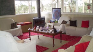 Ein gemütliches Wohnzimmer mit Kamin, weißen Möbeln und einem roten Teppich.