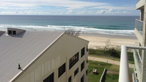 Un edificio alto con vista a la playa y al océano.