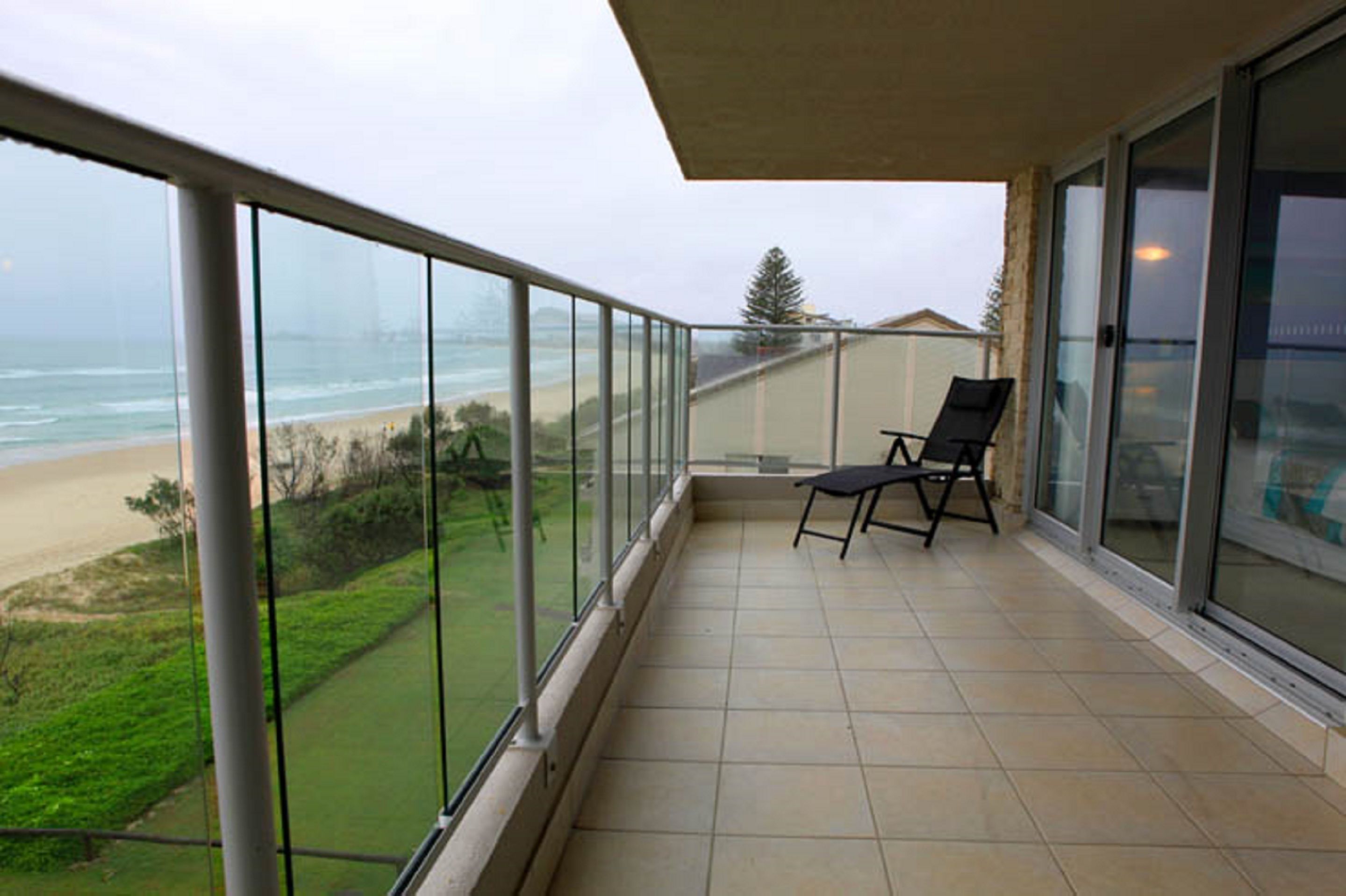 Un balcon avec vue sur la plage et l’océan.