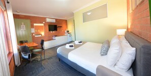 A hotel room with a bed, a desk, a chair, a TV, and a microwave. - Bendigo Goldfields Motor Inn (Golden Square)