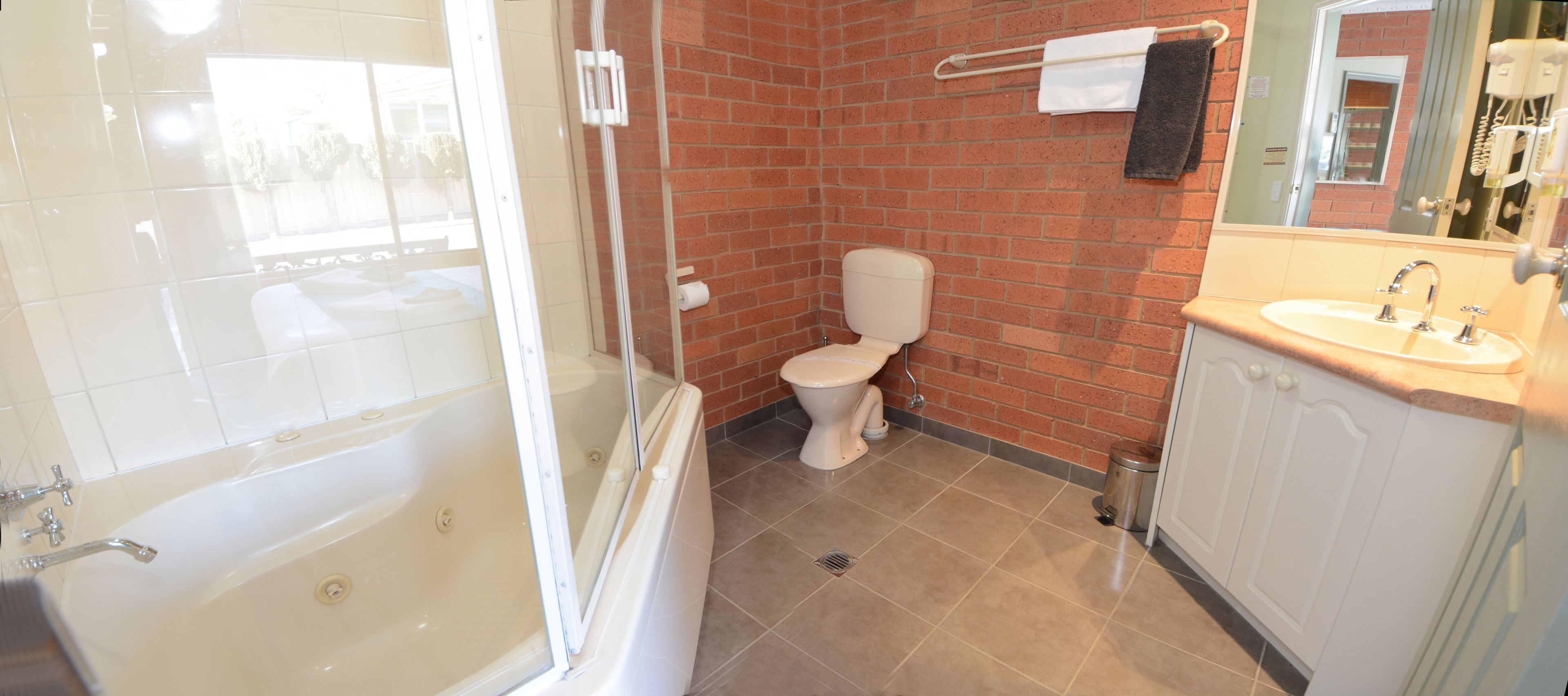 A bathroom with a bathtub, toilet, and sink.