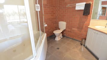 A bathroom with a bathtub, toilet, and sink.