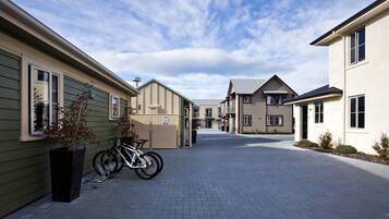 A residential street with houses, a bicycle, and a paved walkway.