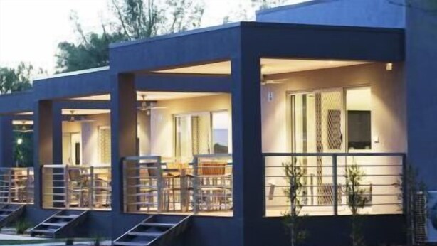 A modern building with multiple balconies and a well-maintained lawn. - Ski Club Holiday Park (Mulwala)
