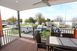 A balcony with a view of a parking area, outdoor furniture, and a building in the background. - Ski Club Holiday Park (Mulwala)