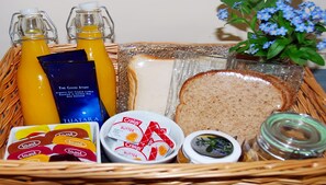 A breakfast tray with toast, butter, jam, juice, and coffee.