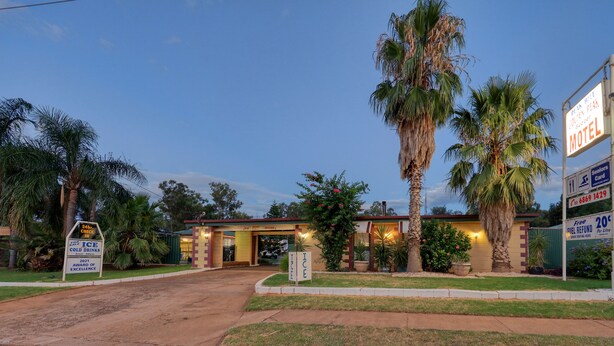 Un motel con un letrero que indica recepción las 24 horas, reembolso del 20% en combustible y un premio al mérito de 2021.