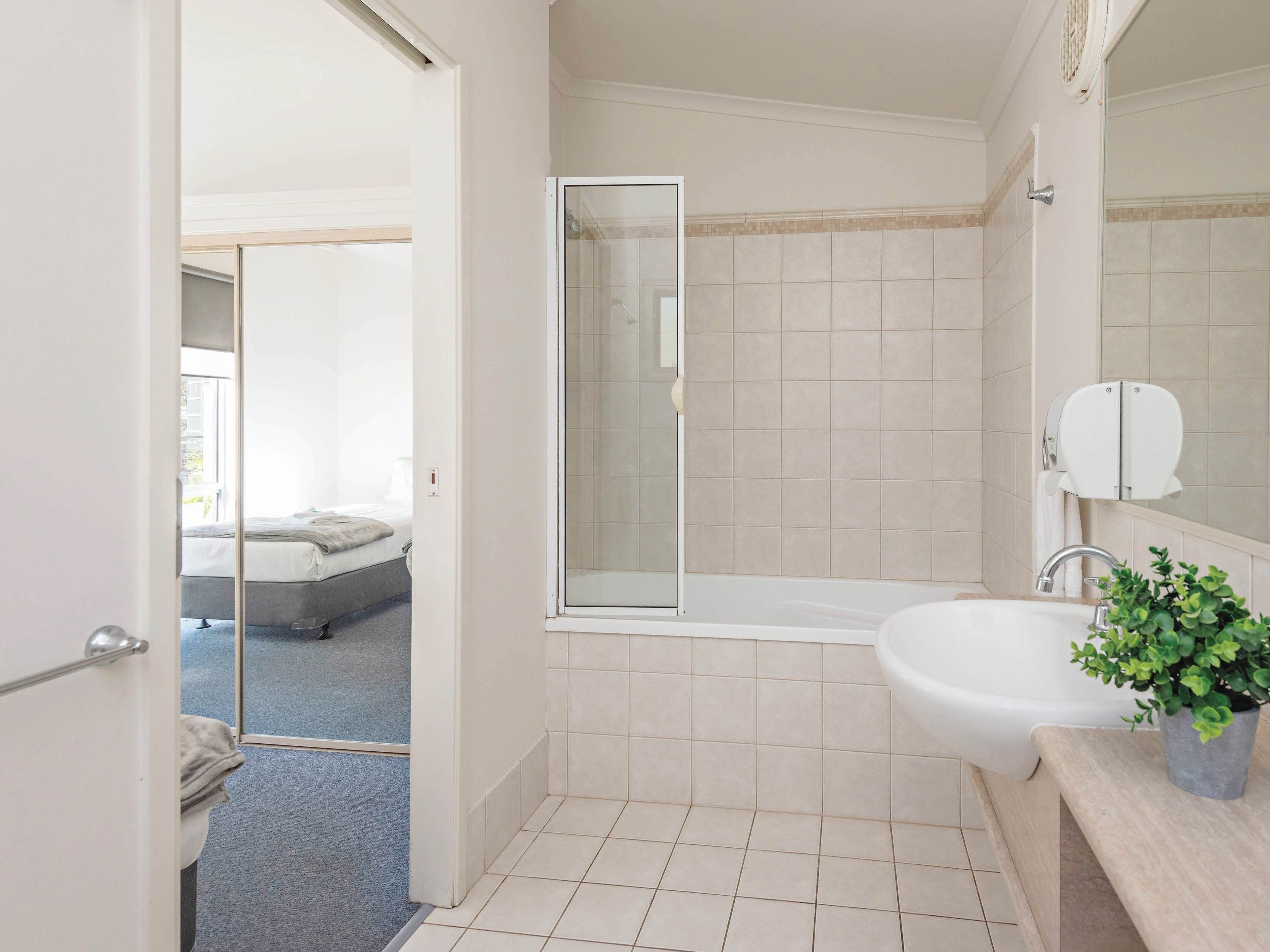 A modern bathroom with a bathtub, a sink, and a shower.