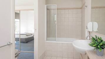 A modern bathroom with a bathtub, a sink, and a shower.