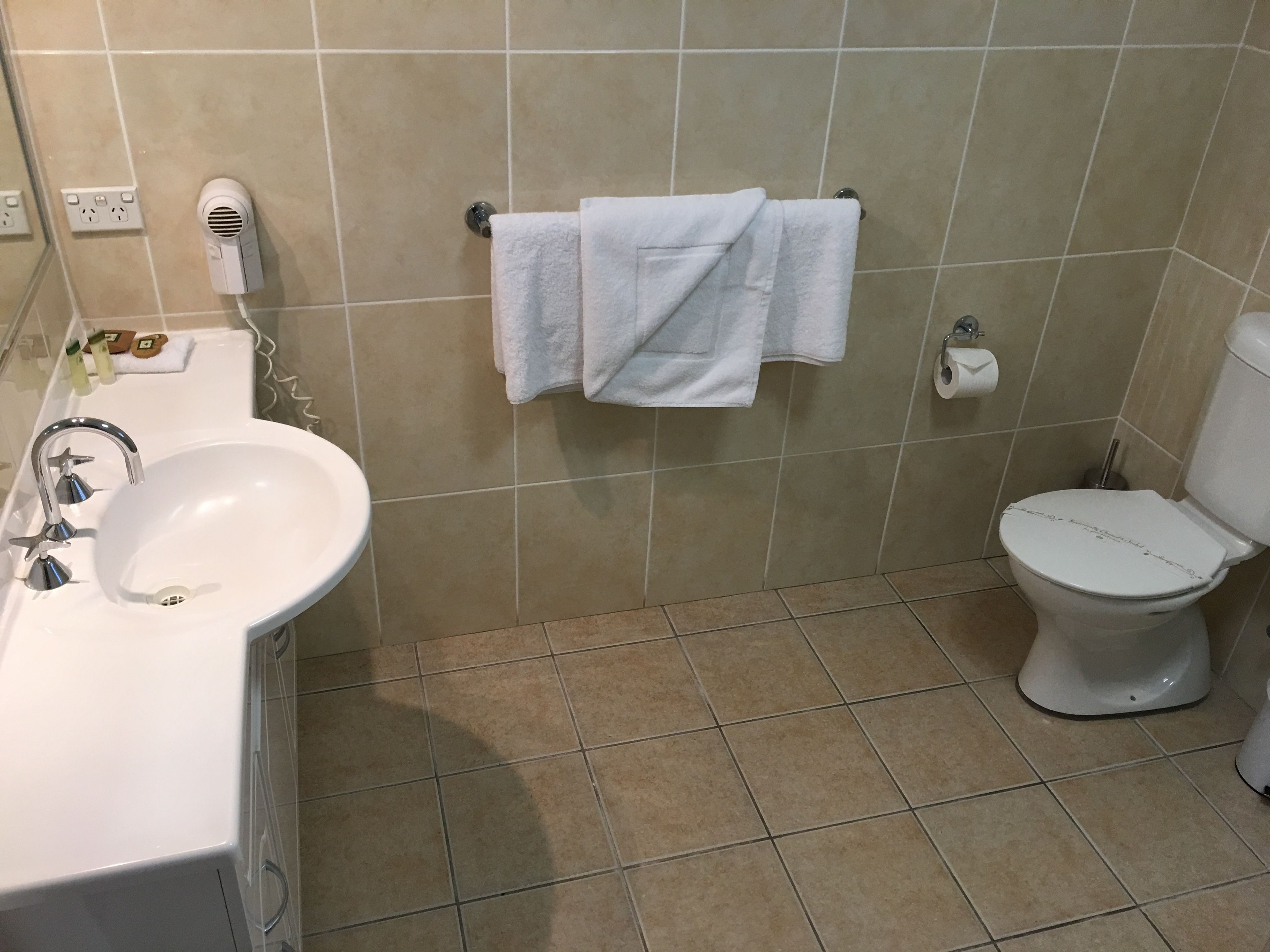 A bathroom with a sink, toilet, and a towel rack.
