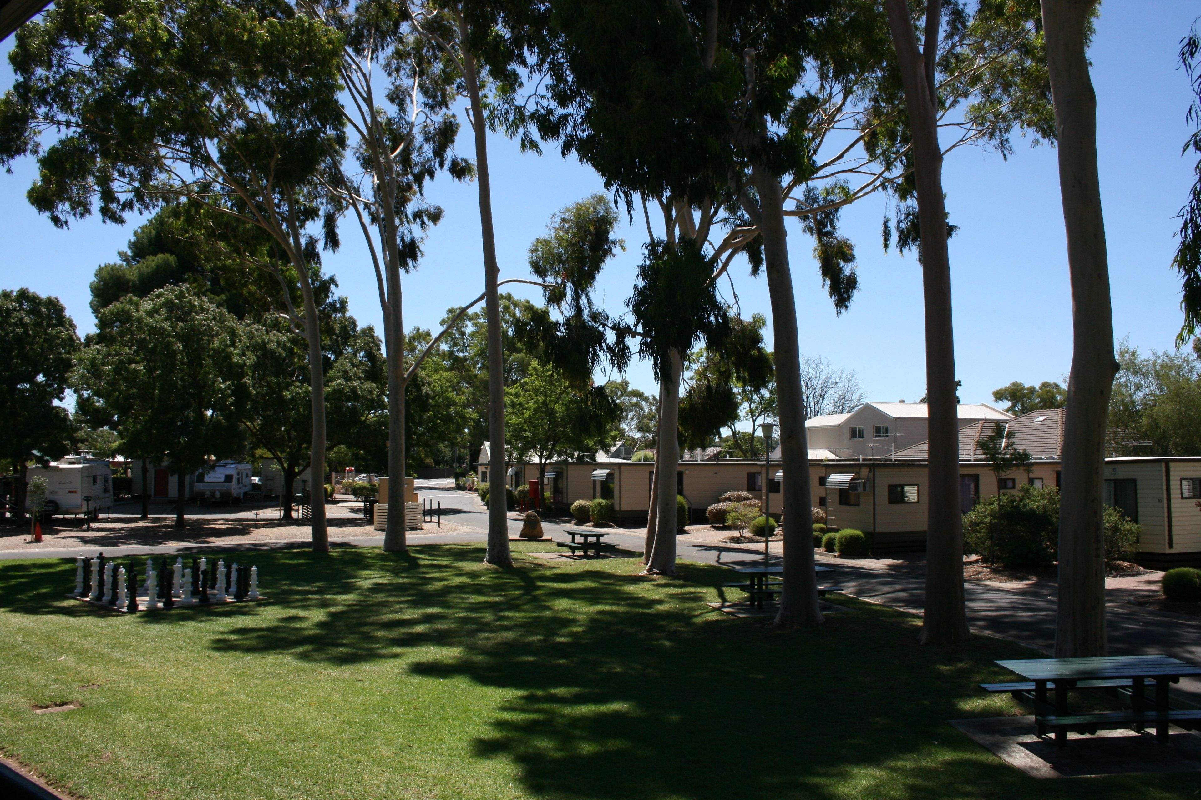 A campground with picnic tables, a grassy area, and mobile homes.
