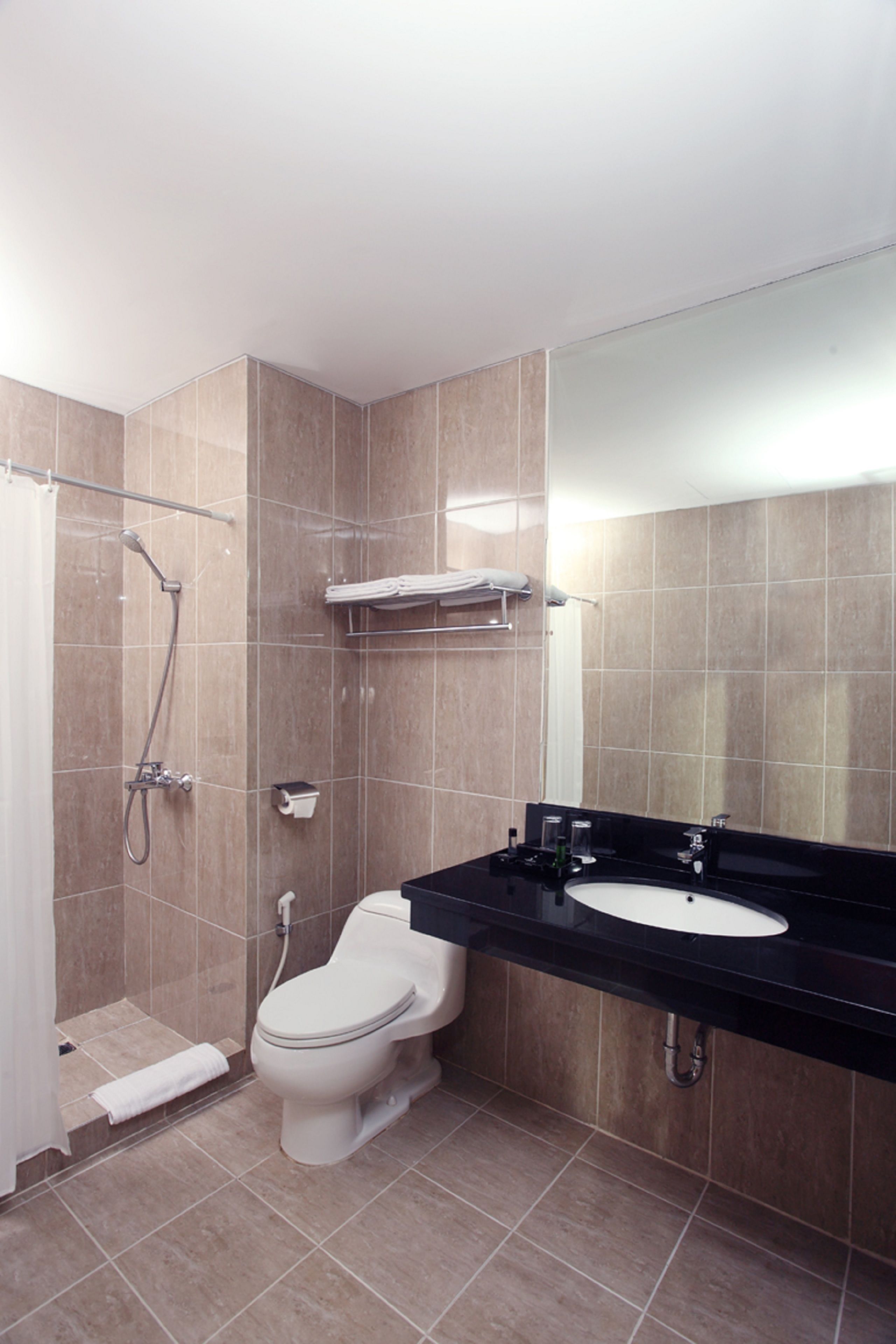 A modern bathroom with a toilet, sink, and shower.