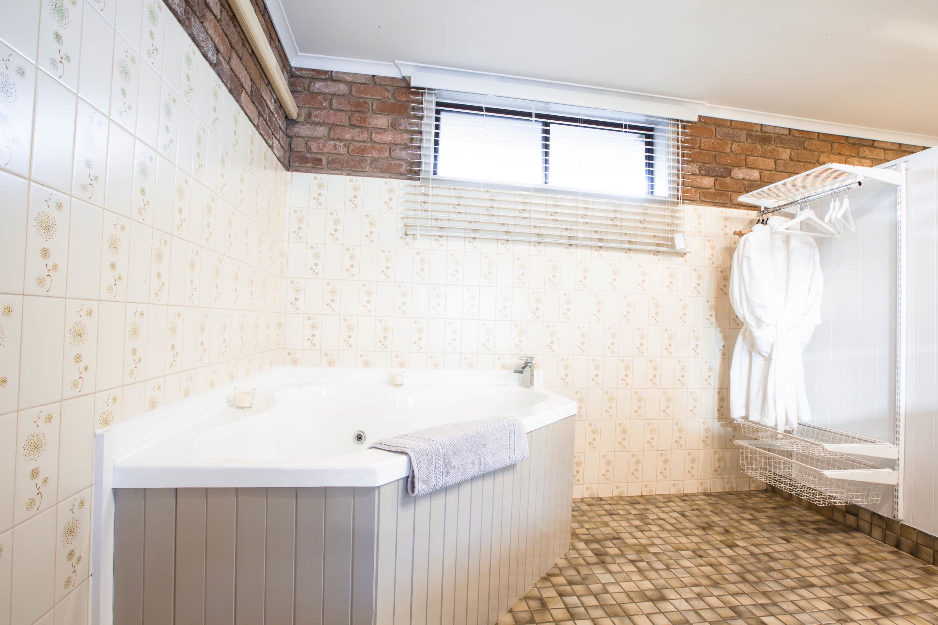 Ein Badezimmer mit einer Badewanne, einem Fenster und einer Duschkabine.