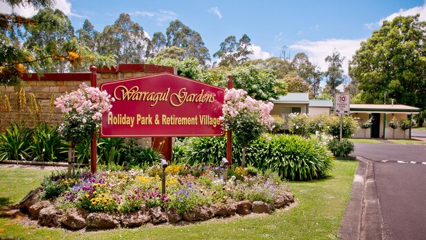 A sign for Waragul Gardens, Holiday Park & Retirement Village, with a well-maintained garden and a 10 km shared zone sign. - Warragul Gardens Holiday Park (Warragul)