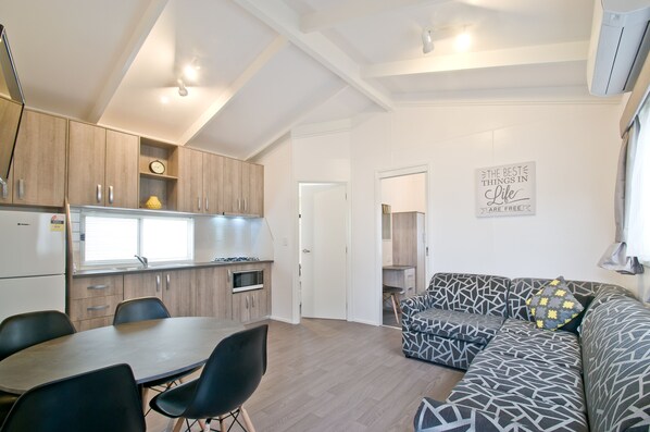 Un espacio habitable moderno con cocina, comedor y un sofá estampado.