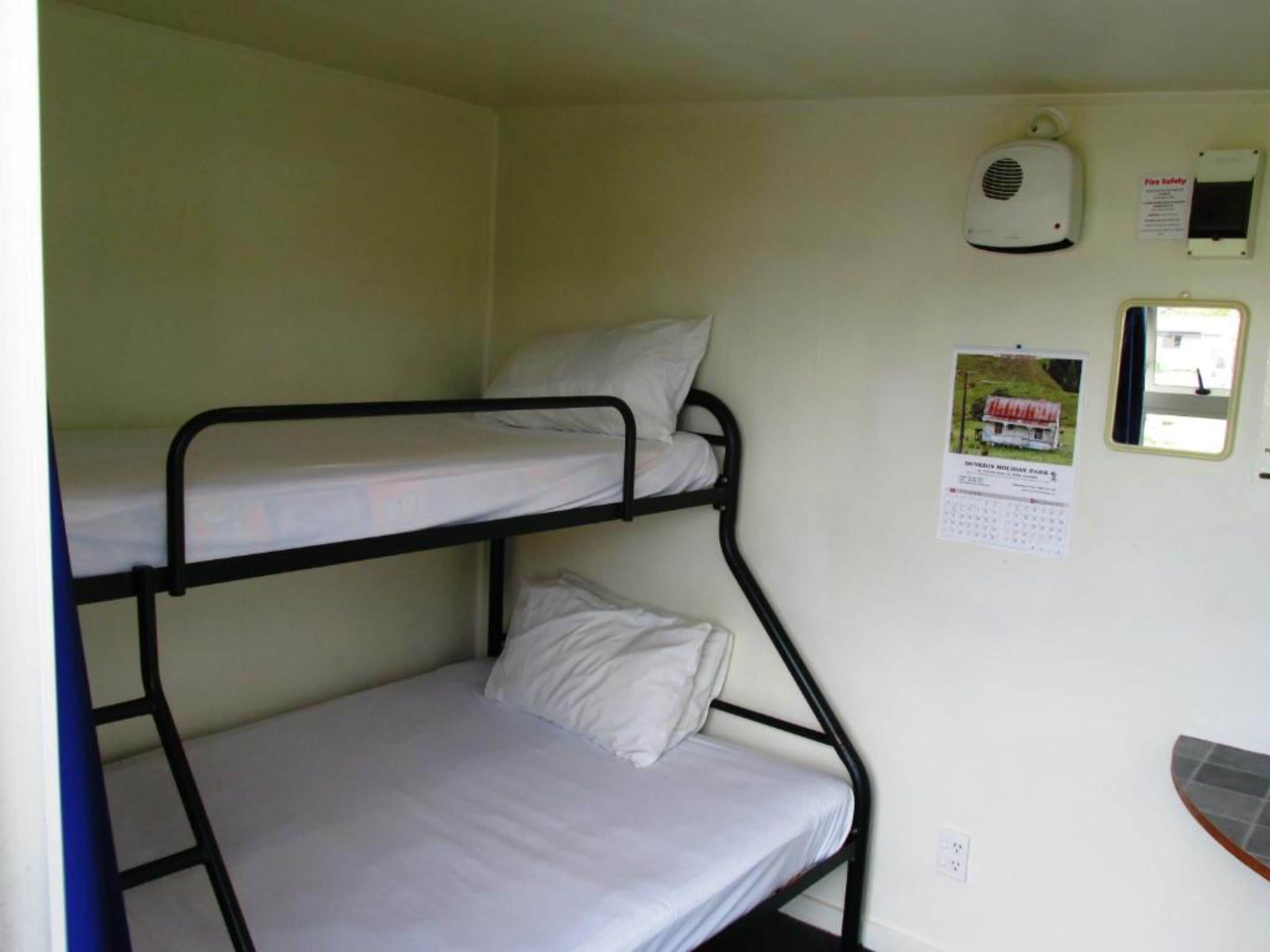A bunk bed room with a fire safety sign, a calendar, and a small window.