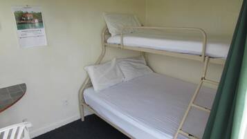 A bunk bed room with a small table and a poster on the wall.