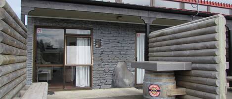 A building with a stone facade, a wooden door, and a large barrel labeled "Speights Good Medal Ale".