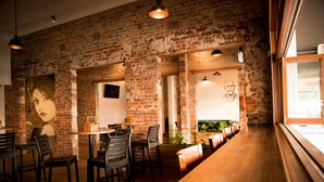 A restaurant with brick walls, wooden tables, and chairs.