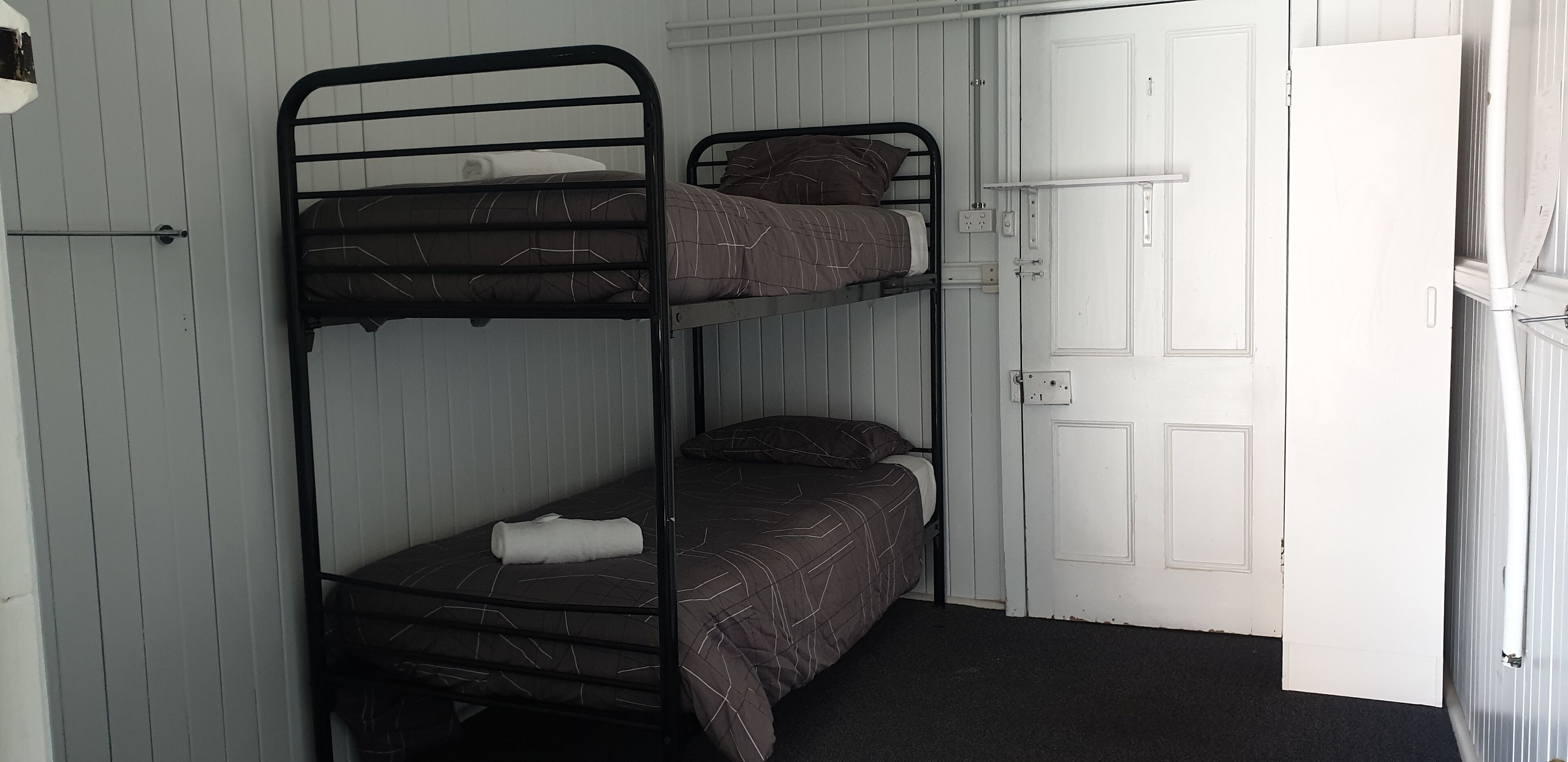 Quarto com beliche, porta branca e radiador.