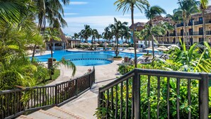 A resort with a large swimming pool surrounded by palm trees and lounge chairs. - Catalonia Yucatan Beach - All Inclusive (Puerto Aventuras)