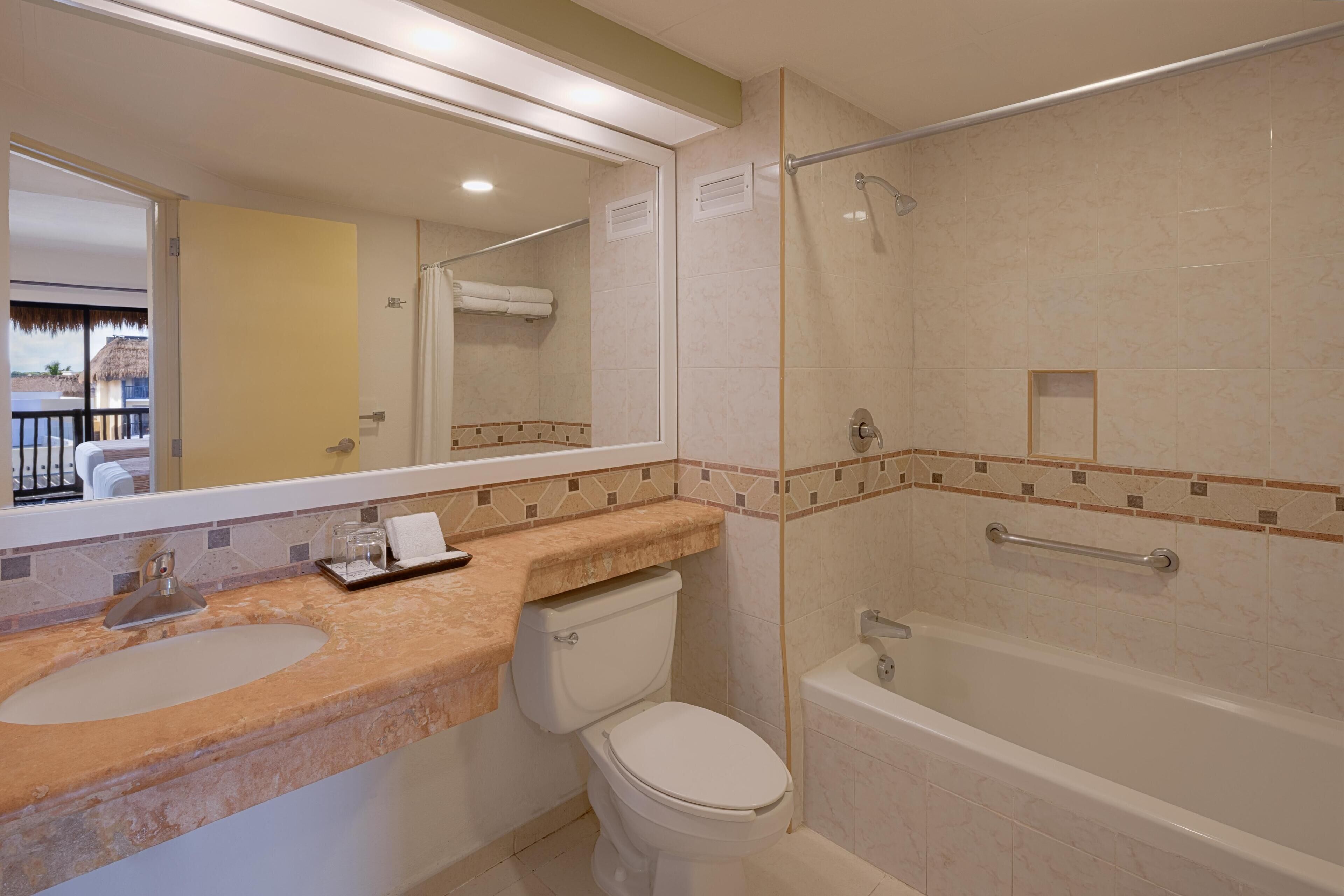 Une salle de bain avec un lavabo, des toilettes et une baignoire.