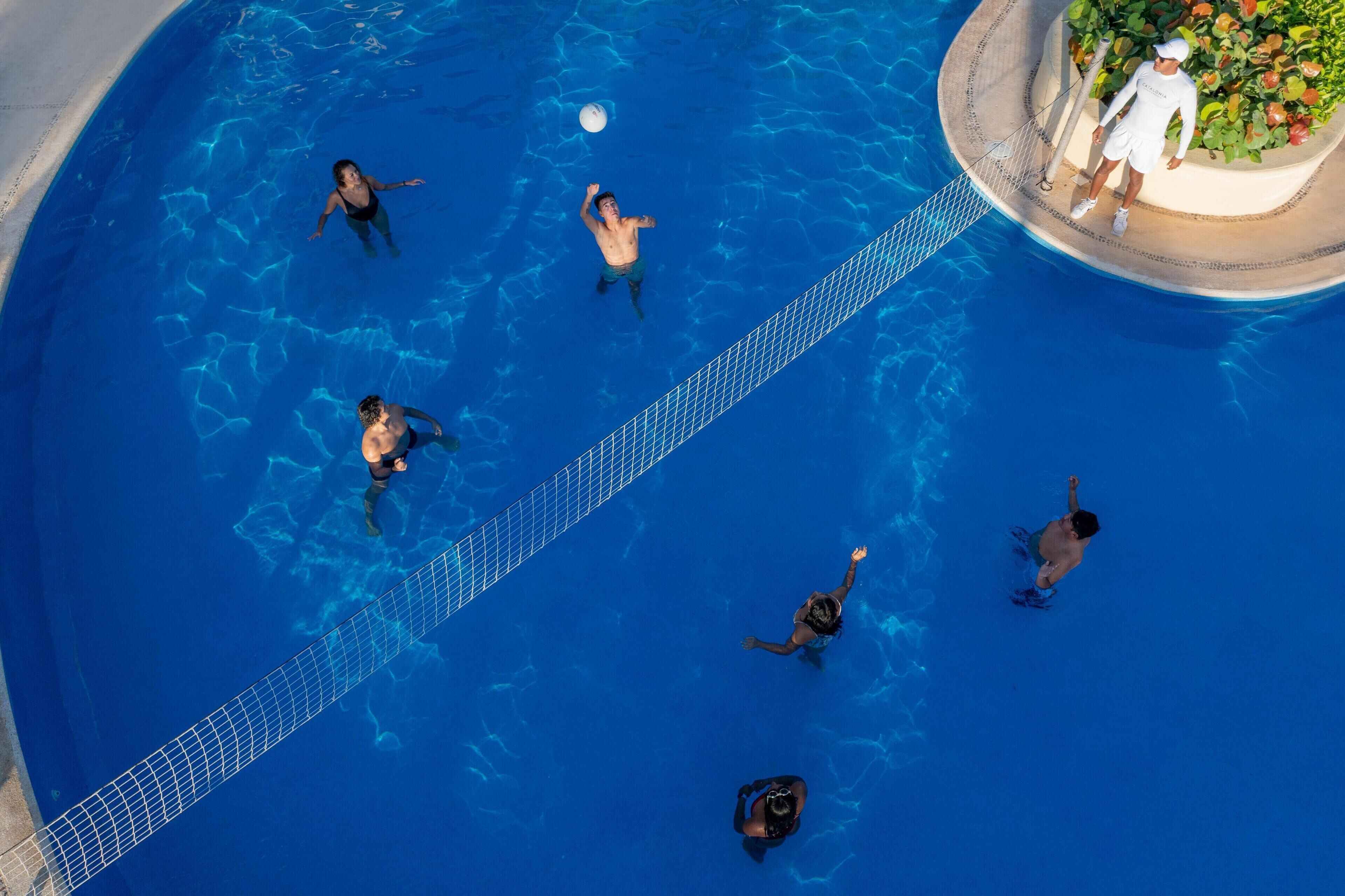 Luftaufnahme eines Schwimmbeckens, in dem Menschen schwimmen und spielen.