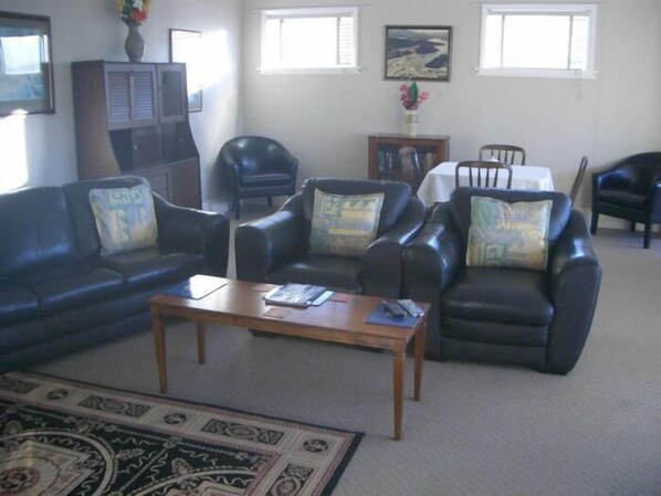 A living room with a sofa set, a coffee table, and a TV stand.