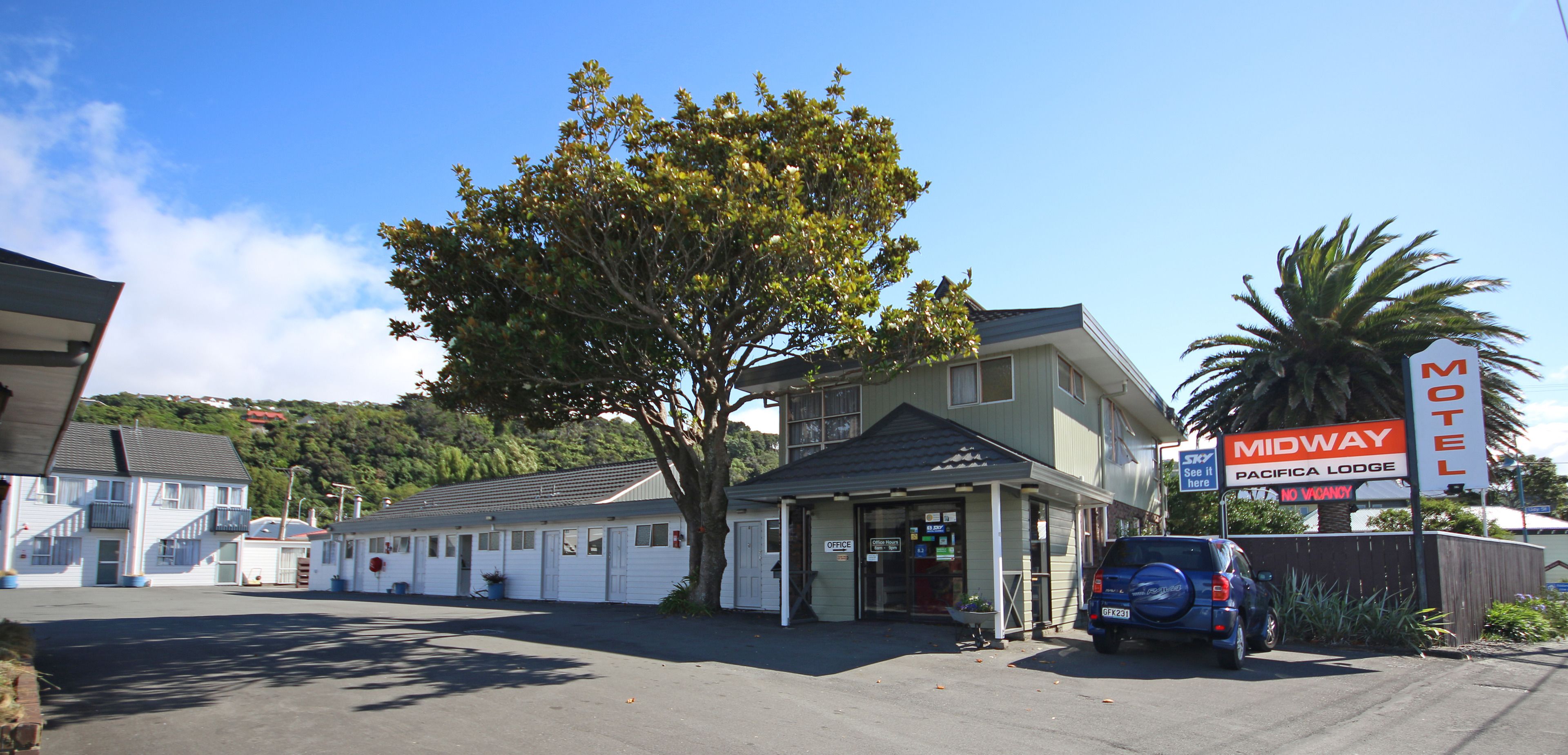 Un motel avec une enseigne indiquant « Midway Pacifica Lodge » et « Complet ».