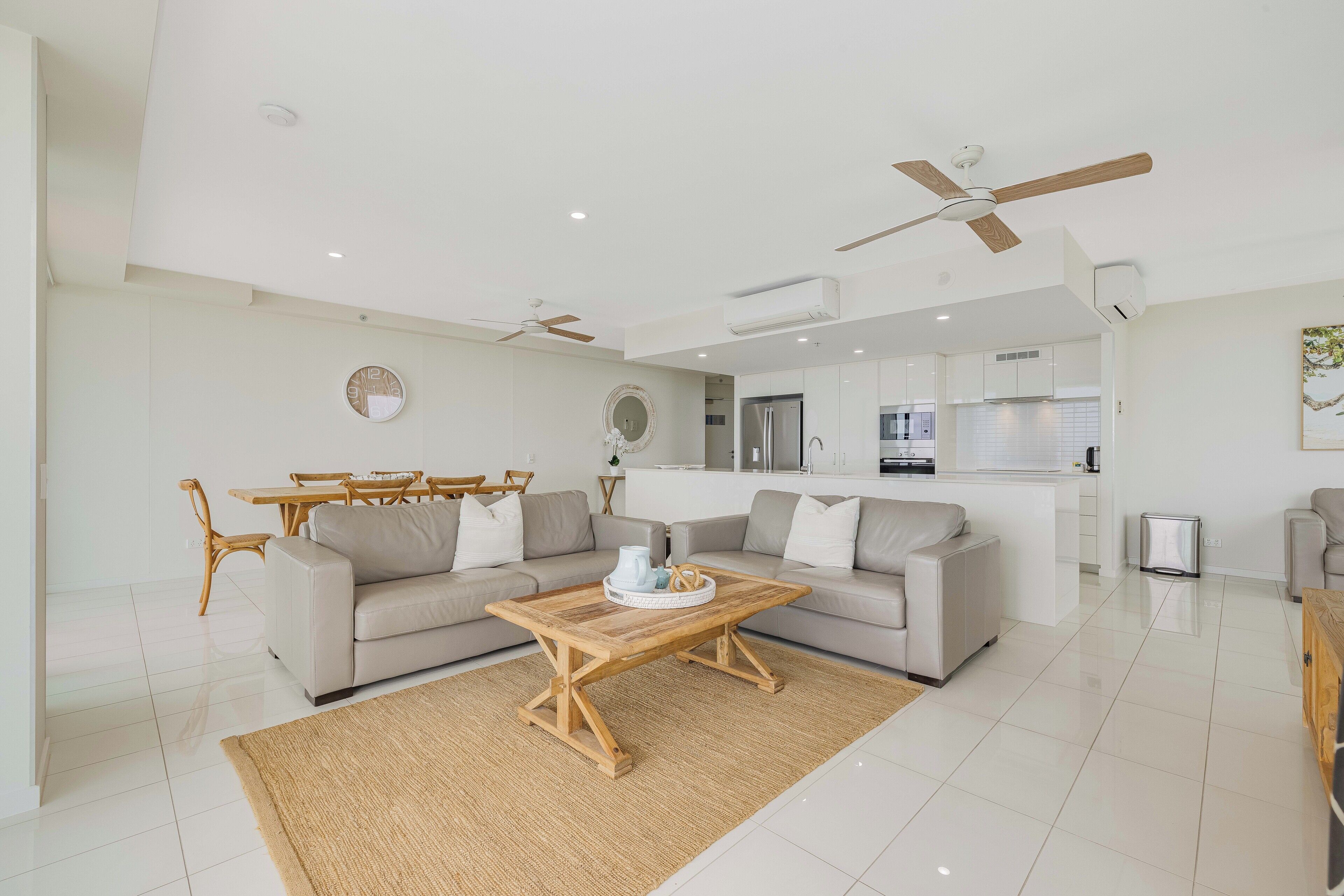 A modern living room with a sofa, coffee table, and dining area.