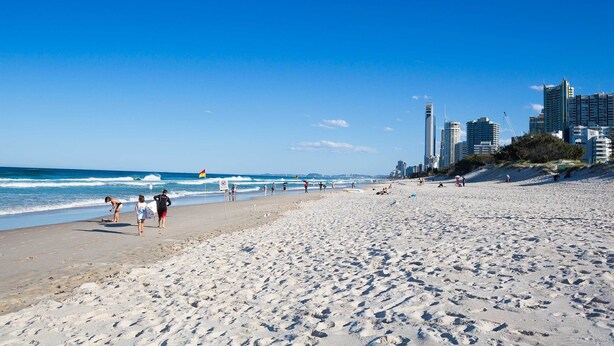 A beach with a city skyline in the background. - Main Beach Tourist Park (Main Beach)