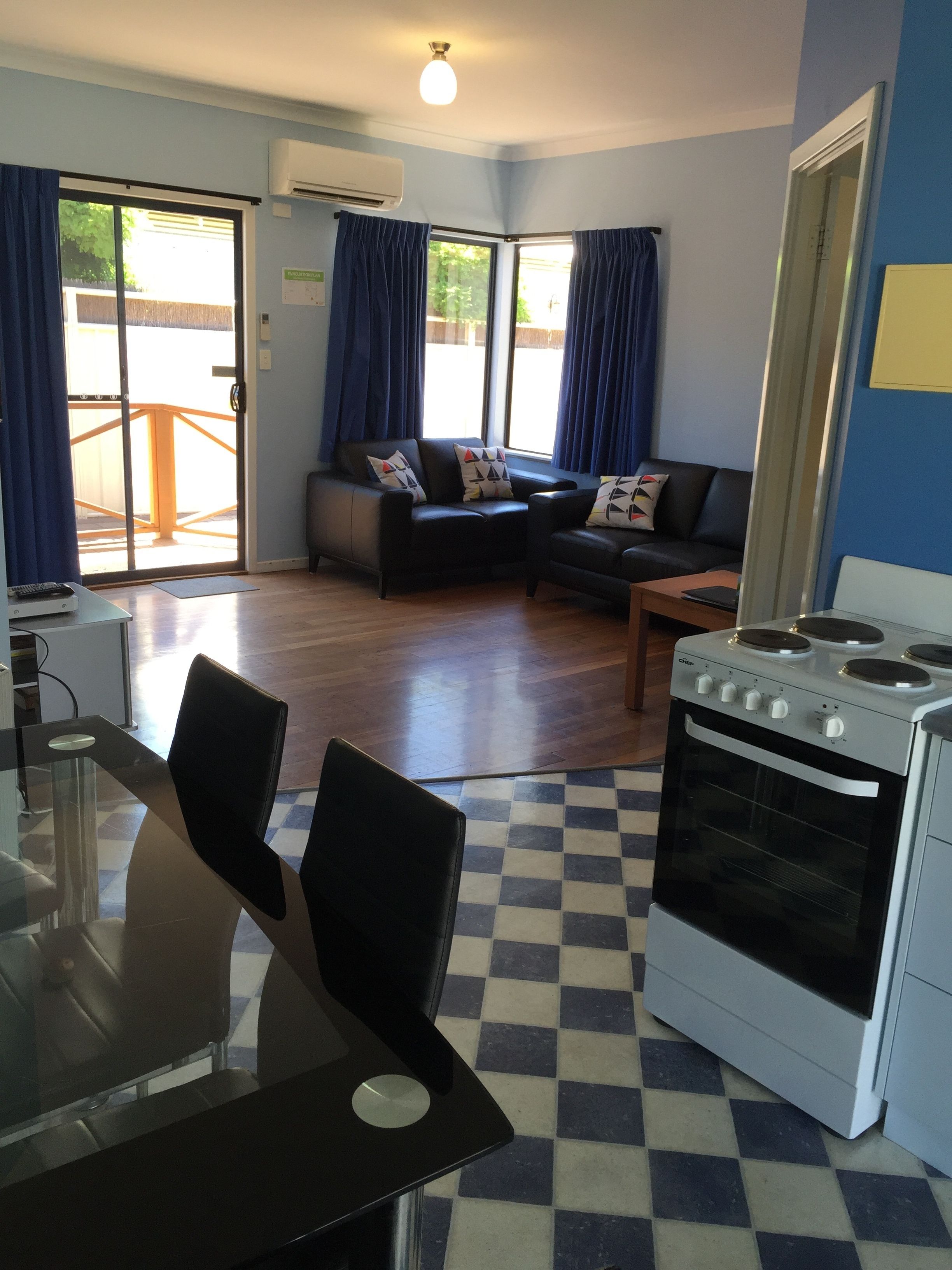 A compact living space with a kitchenette, a dining area, and a seating area with a sofa and chairs.