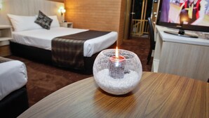 A hotel room with a bed, bedside table, TV, and a decorative glass sphere with a candle. - River City Motel (Mildura)