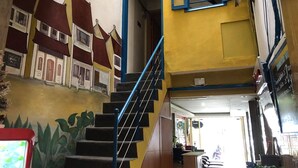 A staircase with a blue handrail leading to a landing. - Box Hotel (Hanoi)