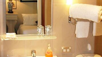 A bathroom with a sink, mirror, and toilet.