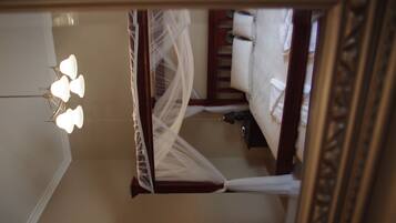 A room with a bed, a nightstand, a lamp, and a mirror.