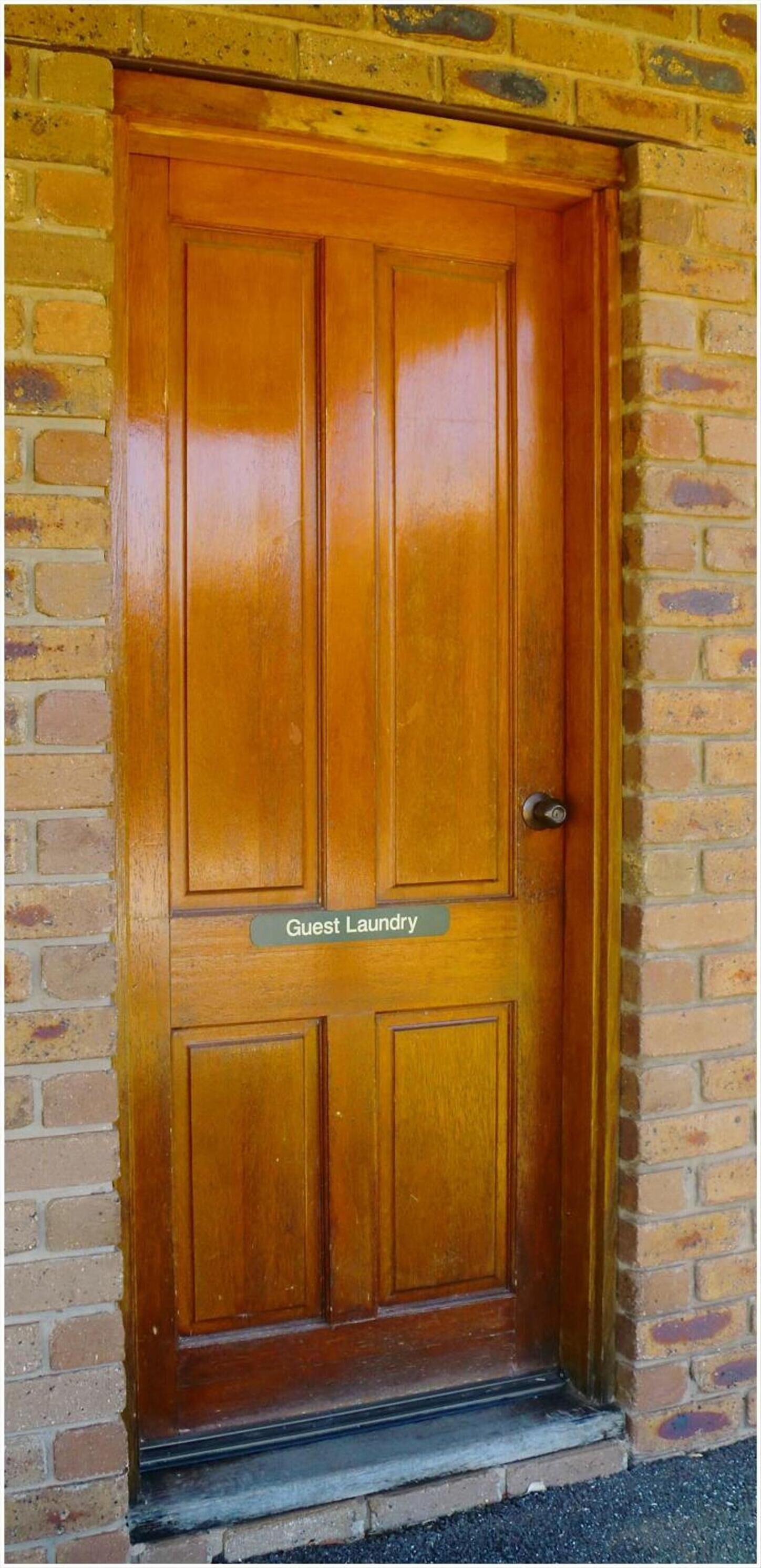 A wooden door with a sign reading "Guest Laundry" above it.