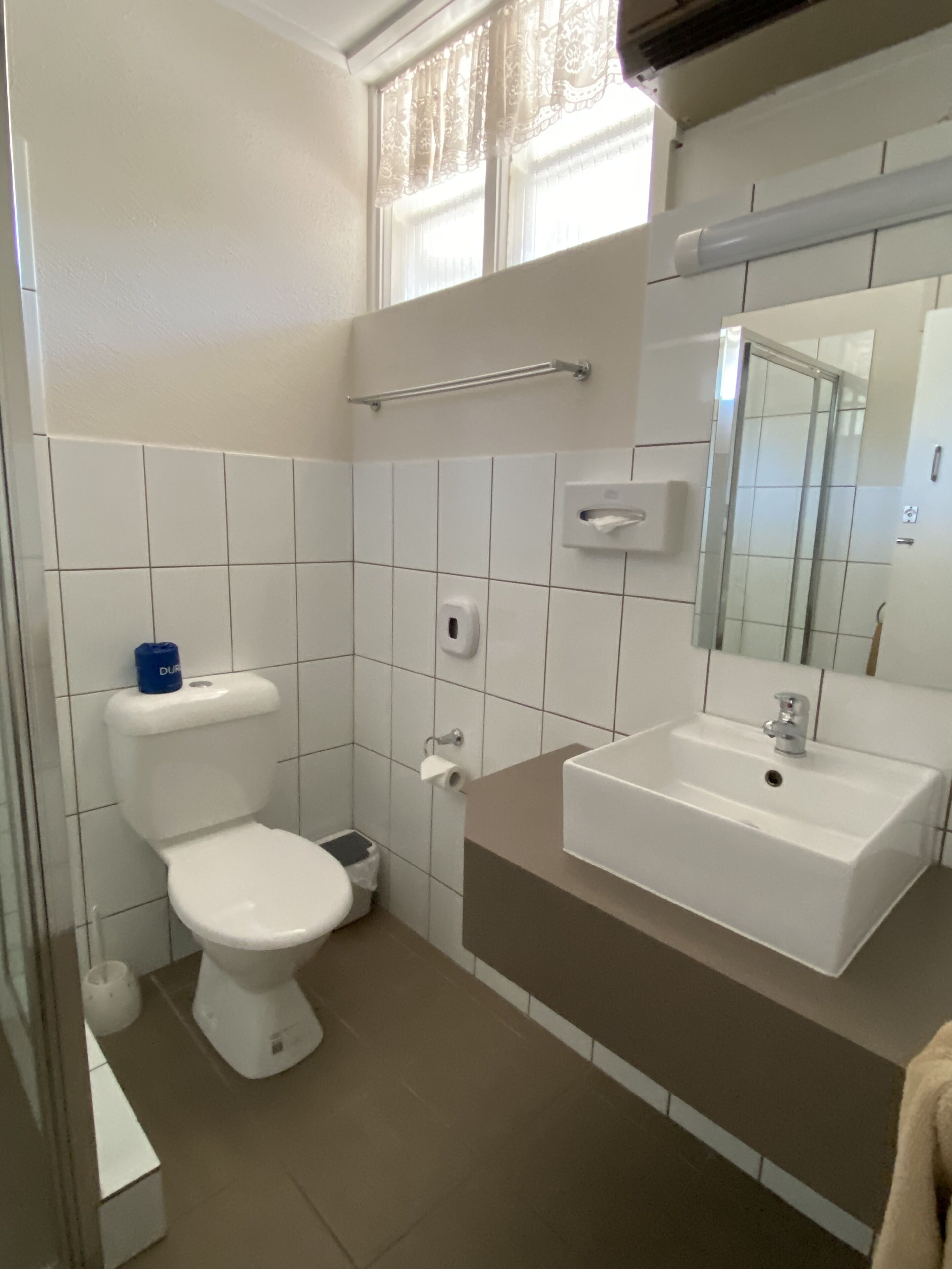 Ein Badezimmer mit Toilette, Waschbecken und Spiegel.